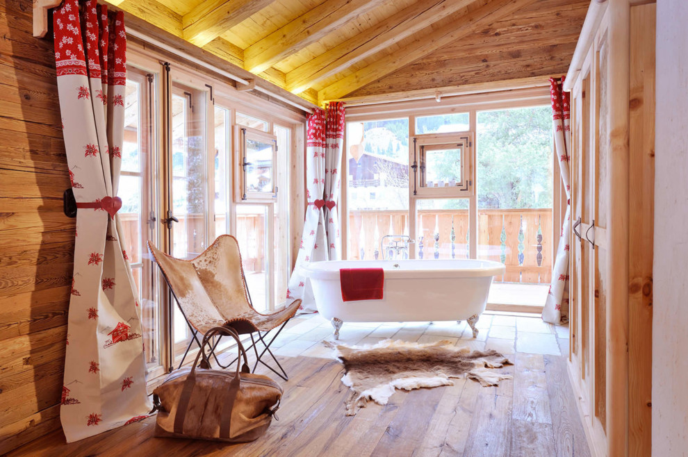 Inspiration för ett rustikt badrum, med ett badkar med tassar och ljust trägolv