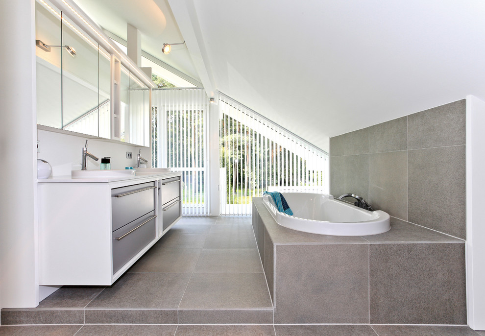 Источник вдохновения для домашнего уюта: большая ванная комната в современном стиле с накладной раковиной, плоскими фасадами, серыми фасадами, накладной ванной, серой плиткой, каменной плиткой, белыми стенами и полом из сланца