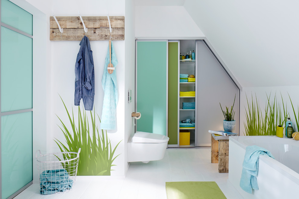 Modernes Badezimmer mit flächenbündigen Schrankfronten, Einbaubadewanne, Wandtoilette, weißer Wandfarbe, weißen Fliesen und Keramikfliesen in Sonstige