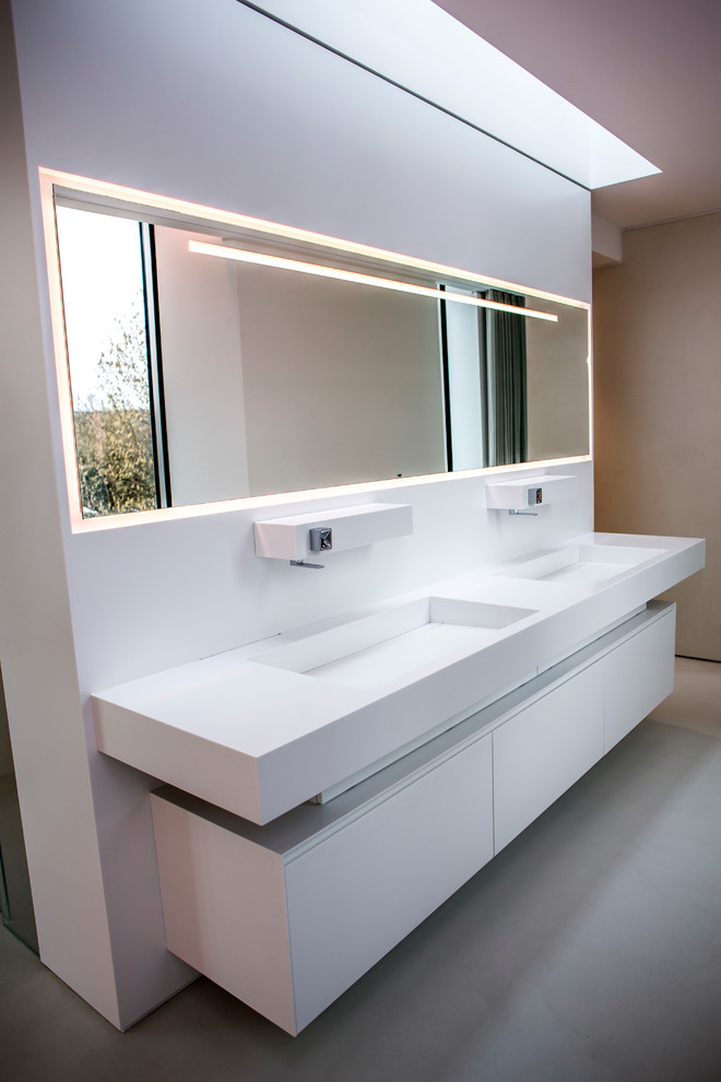 Esempio di una stanza da bagno con doccia moderna con ante bianche, doccia a filo pavimento, pareti bianche, pavimento in cemento e lavabo a bacinella
