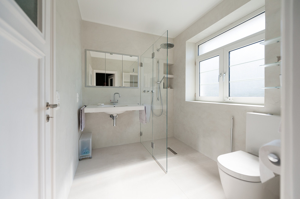 На фото: ванная комната среднего размера в современном стиле с открытым душем, инсталляцией, белыми стенами, душевой кабиной, подвесной раковиной, белым полом и шторкой для ванной с