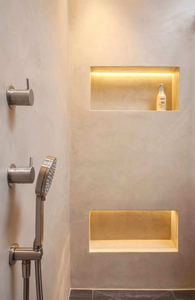 Modern inredning av ett mellanstort badrum med dusch, med släta luckor, vita skåp, en kantlös dusch, beige väggar, ett integrerad handfat, grått golv och dusch med skjutdörr