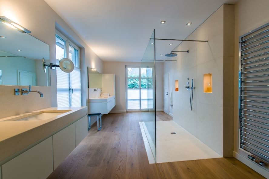 Idée de décoration pour une grande salle d'eau design avec des portes de placard blanches, un plan de toilette en calcaire, une douche à l'italienne, un carrelage beige et des dalles de pierre.