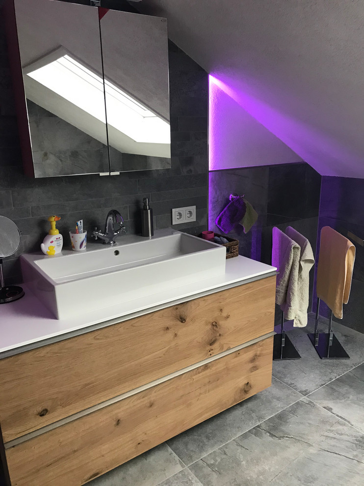 Immagine di una stanza da bagno nordica di medie dimensioni con vasca idromassaggio, doccia ad angolo, piastrelle grigie, pavimento con piastrelle in ceramica e porta doccia scorrevole