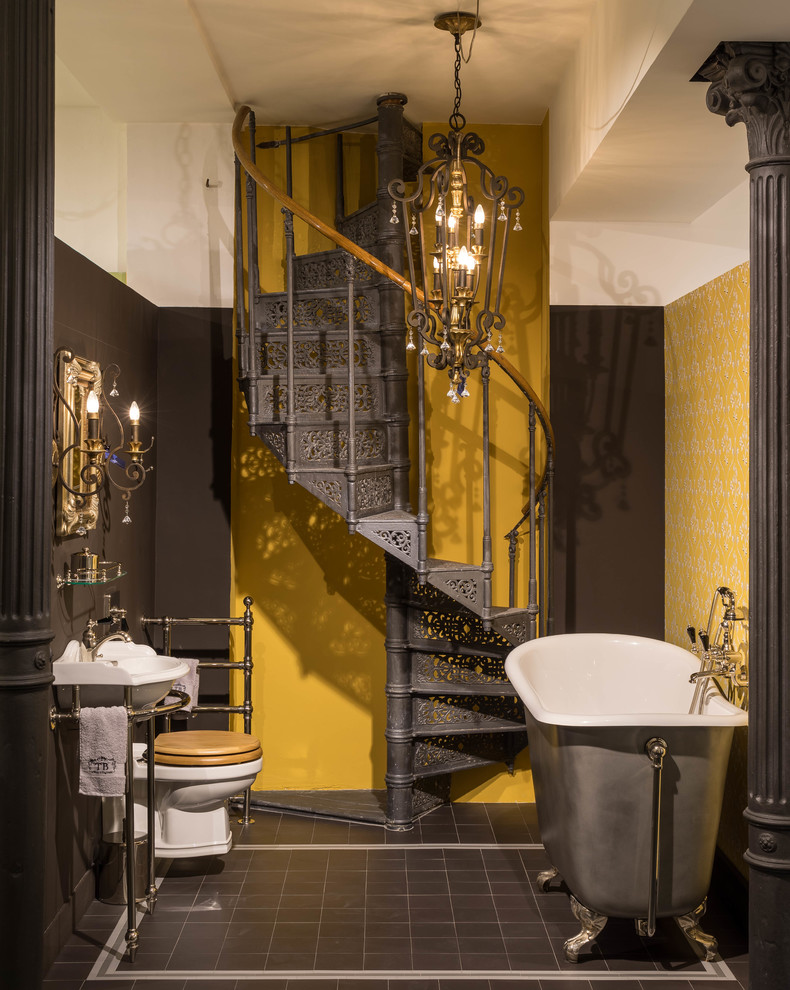 Mittelgroßes Klassisches Badezimmer mit freistehender Badewanne, Wandtoilette mit Spülkasten, gelber Wandfarbe, Keramikboden und braunem Boden in München