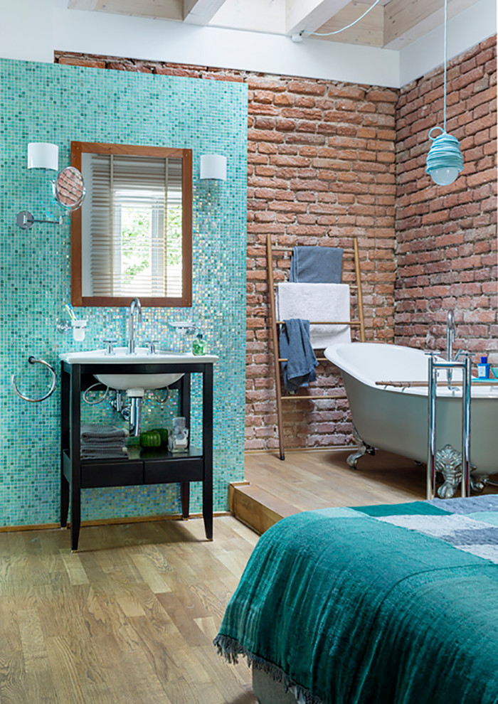 Modern inredning av ett litet en-suite badrum, med ett badkar med tassar, mosaik, blå väggar, ett avlångt handfat, träbänkskiva och med dusch som är öppen