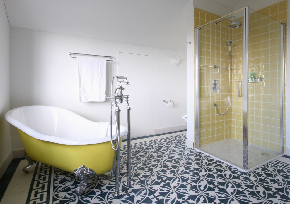Свежая идея для дизайна: большая главная ванная комната в стиле кантри с фасадами с декоративным кантом, белыми фасадами, отдельно стоящей ванной, угловым душем, унитазом-моноблоком, желтой плиткой, керамической плиткой, белыми стенами, полом из цементной плитки, консольной раковиной, синим полом и душем с распашными дверями - отличное фото интерьера