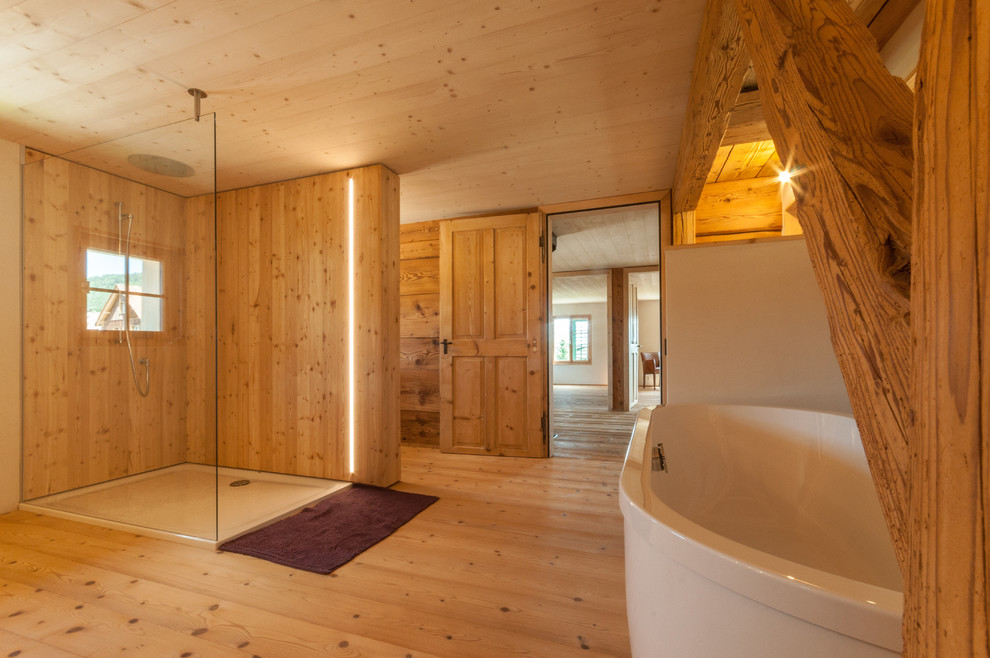 Photo of a large rural shower room bathroom in Other with open cabinets, medium wood cabinets, a freestanding bath, a shower/bath combination, a wall mounted toilet, white walls, dark hardwood flooring, a vessel sink and solid surface worktops.