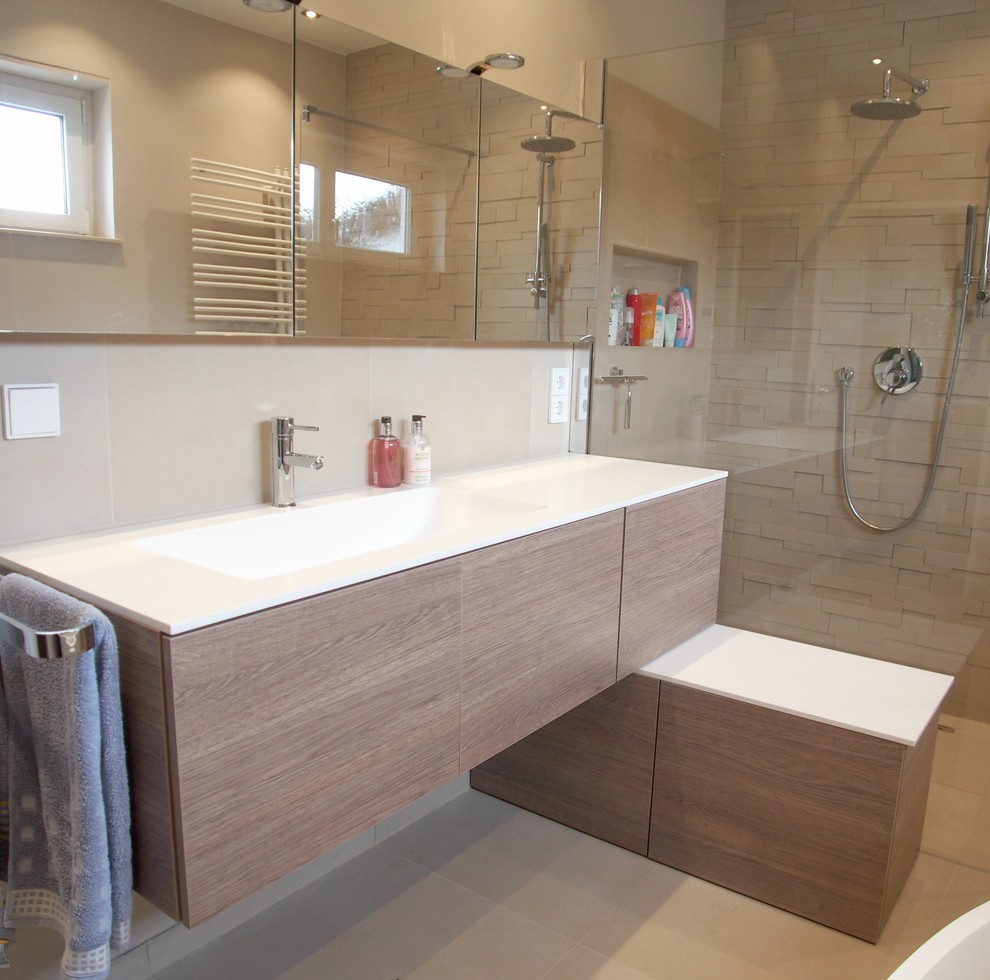 Modernes Badezimmer mit freistehender Badewanne, offener Dusche, beigen Fliesen und beiger Wandfarbe in Dresden