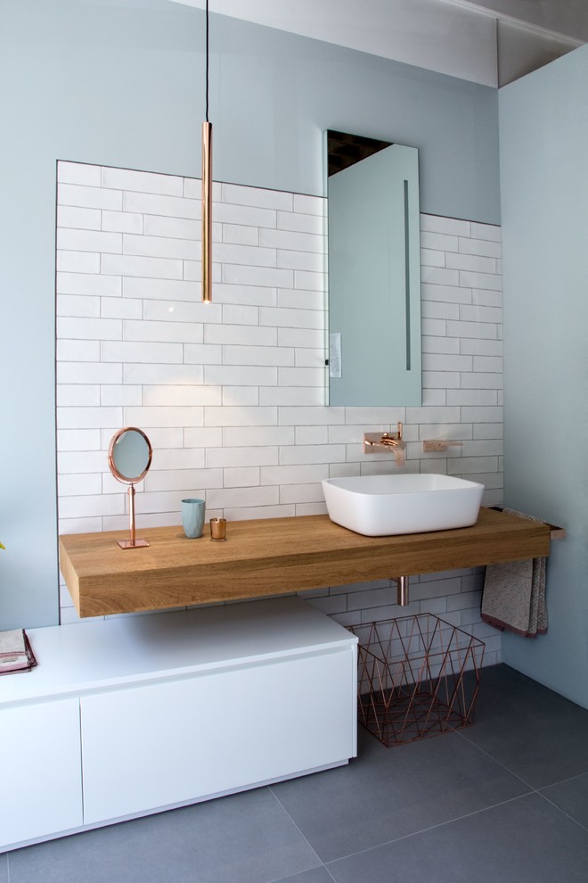 Bild på ett mellanstort skandinaviskt badrum med dusch, med släta luckor, vita skåp, vit kakel, blå väggar, klinkergolv i keramik och grått golv