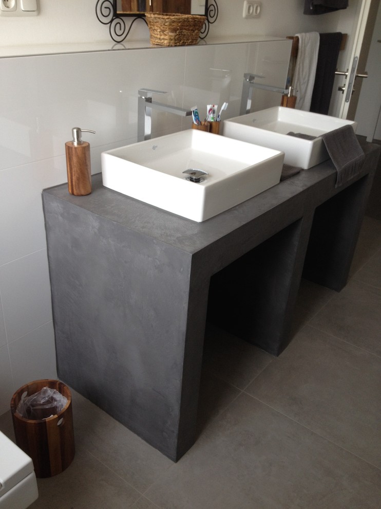 Inspiration för ett mellanstort funkis badrum med dusch, med grå skåp, en vägghängd toalettstol, vita väggar, ett fristående handfat, bänkskiva i betong, grått golv och dusch med gångjärnsdörr