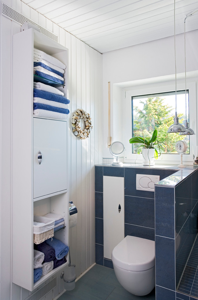 Пример оригинального дизайна: ванная комната среднего размера в морском стиле с плоскими фасадами, белыми фасадами, накладной ванной, угловым душем, раздельным унитазом, синей плиткой, керамической плиткой, белыми стенами, мраморным полом, душевой кабиной, консольной раковиной и столешницей из плитки
