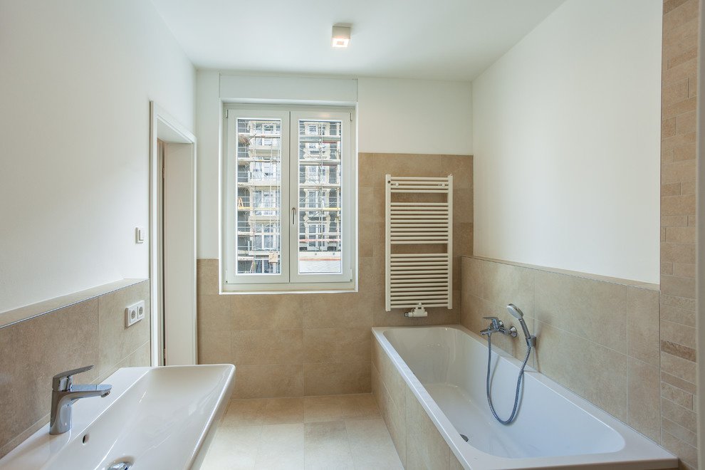 Modernes Badezimmer mit Einbaubadewanne, weißer Wandfarbe, Wandwaschbecken und beigem Boden in Dresden