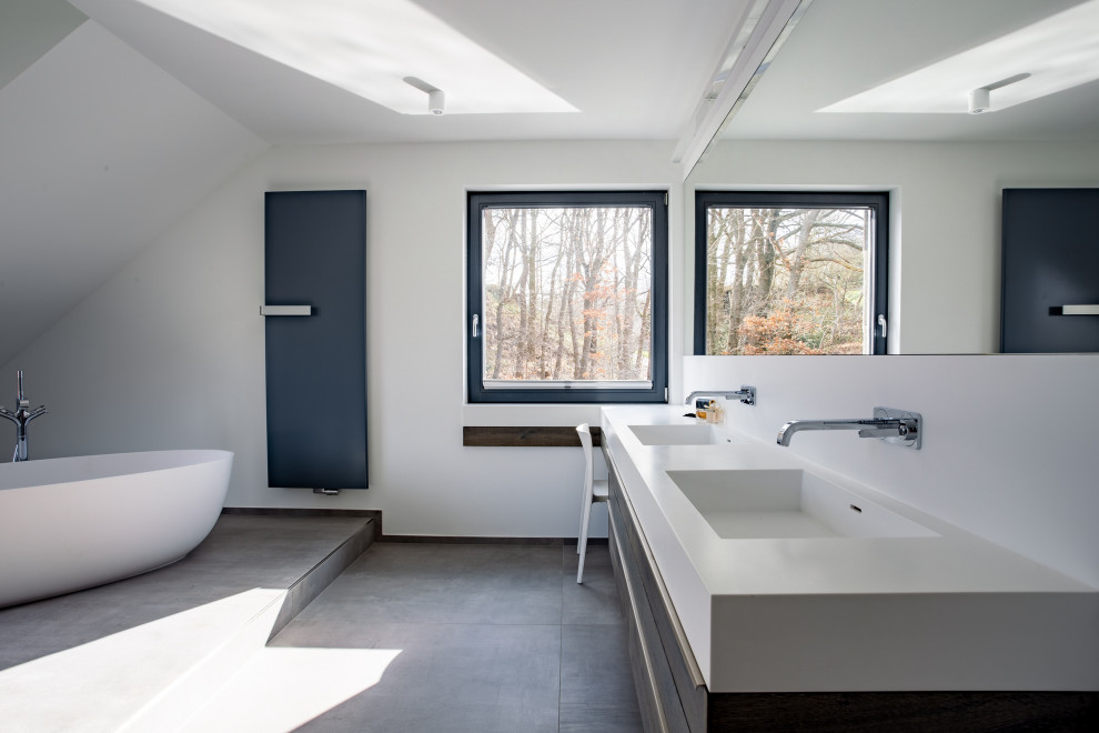 Bathroom - large modern double-sink bathroom idea in Dortmund with flat-panel cabinets, dark wood cabinets, white walls, solid surface countertops, white countertops and a floating vanity