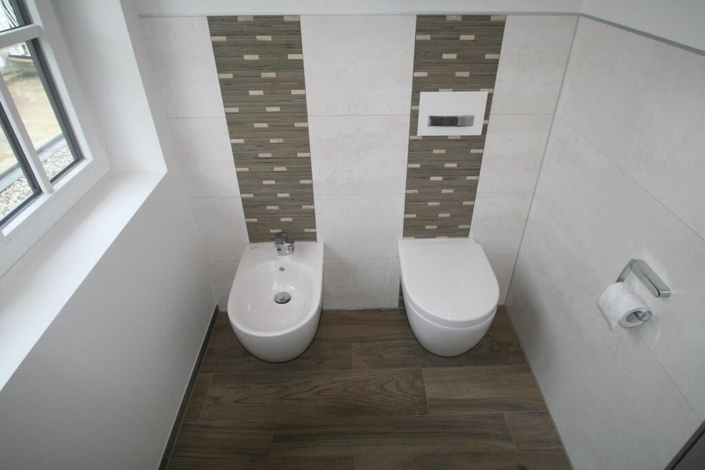 Photo of a large contemporary ensuite bathroom in Cologne with flat-panel cabinets, white cabinets, a built-in bath, a corner shower, a wall mounted toilet, white tiles, porcelain tiles, white walls, laminate floors, a vessel sink, wooden worktops, brown floors and an open shower.