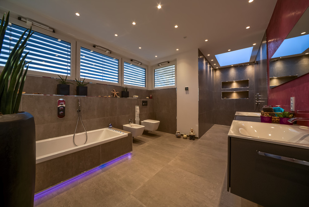 Inspiration for a contemporary ensuite bathroom in Essen with flat-panel cabinets, brown cabinets, a built-in bath, an alcove shower, a bidet, grey tiles, stone tiles, red walls, concrete flooring, a built-in sink, wooden worktops, grey floors, an open shower and brown worktops.