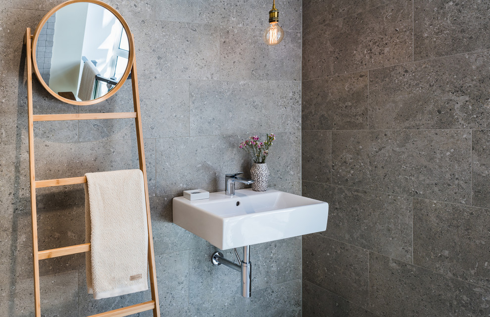 Свежая идея для дизайна: ванная комната в скандинавском стиле с серой плиткой и подвесной раковиной - отличное фото интерьера