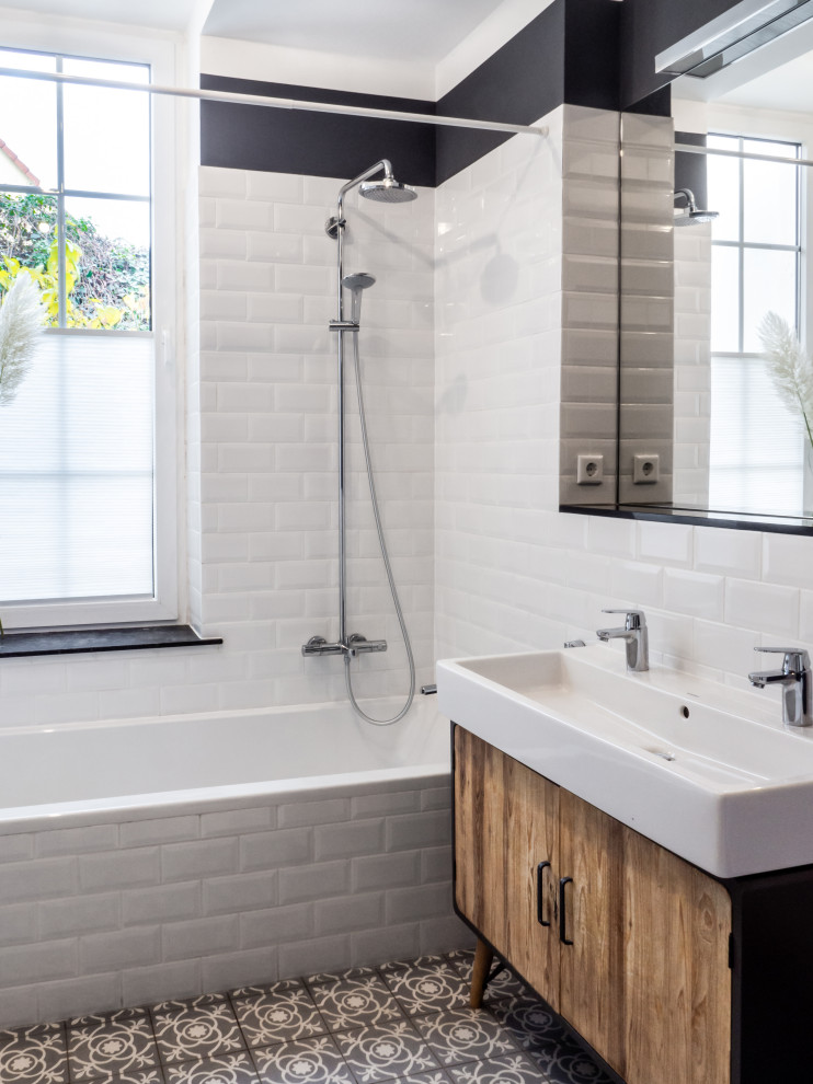 Idée de décoration pour une salle de bain tradition en bois brun de taille moyenne avec une baignoire posée, un carrelage blanc, un carrelage métro, un mur gris, carreaux de ciment au sol, un lavabo suspendu et un sol gris.