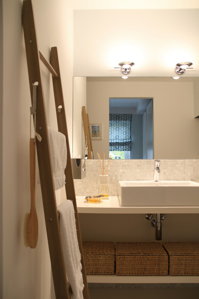 Idéer för ett modernt vit en-suite badrum, med öppna hyllor, vita skåp, en kantlös dusch, grå kakel, mosaik, vita väggar, betonggolv och träbänkskiva