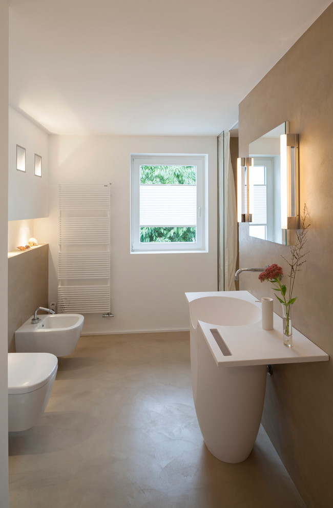Foto de cuarto de baño contemporáneo de tamaño medio con sanitario de pared, suelo de cemento, aseo y ducha, lavabo integrado, encimera de acrílico, suelo beige, ducha con cortina, ducha empotrada, paredes beige y encimeras blancas