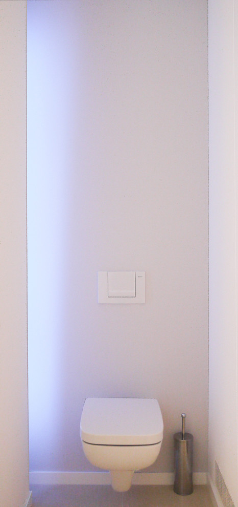 Idéer för ett litet modernt en-suite badrum, med en vägghängd toalettstol, vita väggar, klinkergolv i keramik och grått golv