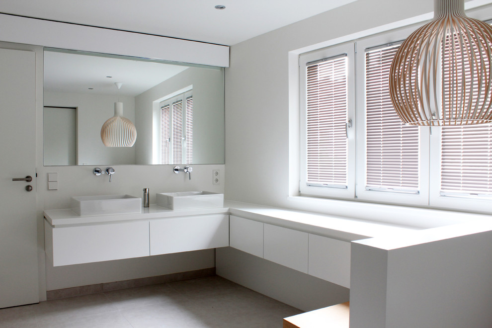 Photo of a large contemporary bathroom in Other with flat-panel cabinets, white cabinets, white walls and a vessel sink.