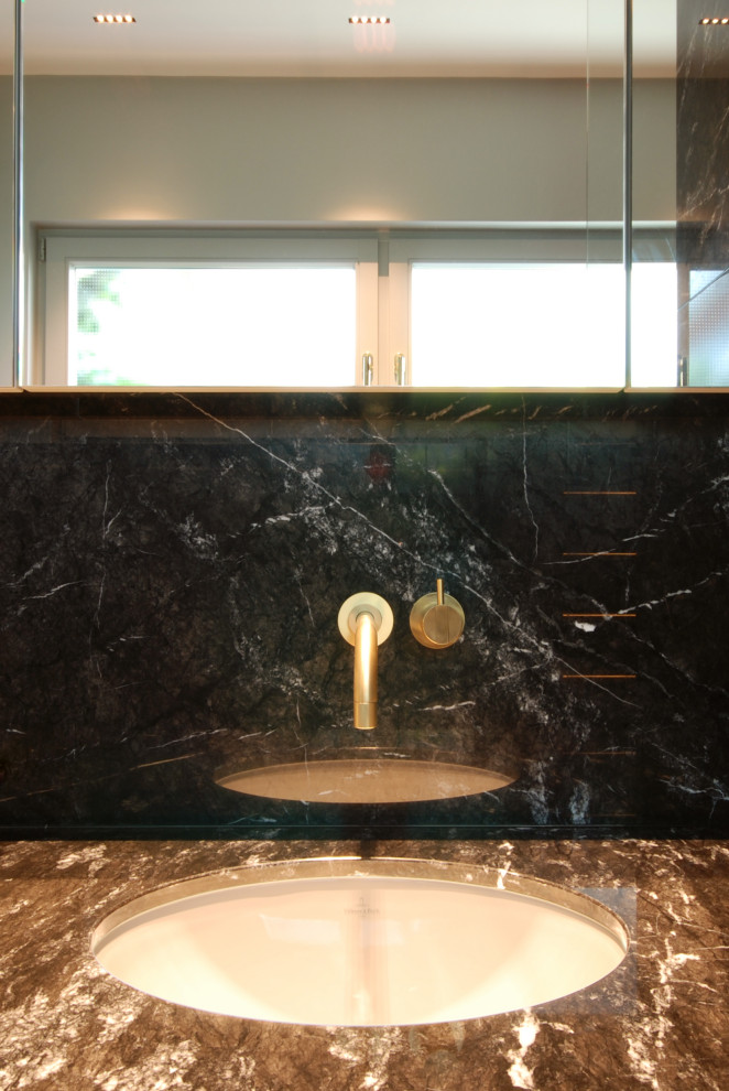 Modern inredning av ett litet svart svart badrum med dusch, med grå skåp, en kantlös dusch, svart kakel, marmorkakel, grå väggar, marmorgolv, ett undermonterad handfat, marmorbänkskiva, svart golv och med dusch som är öppen
