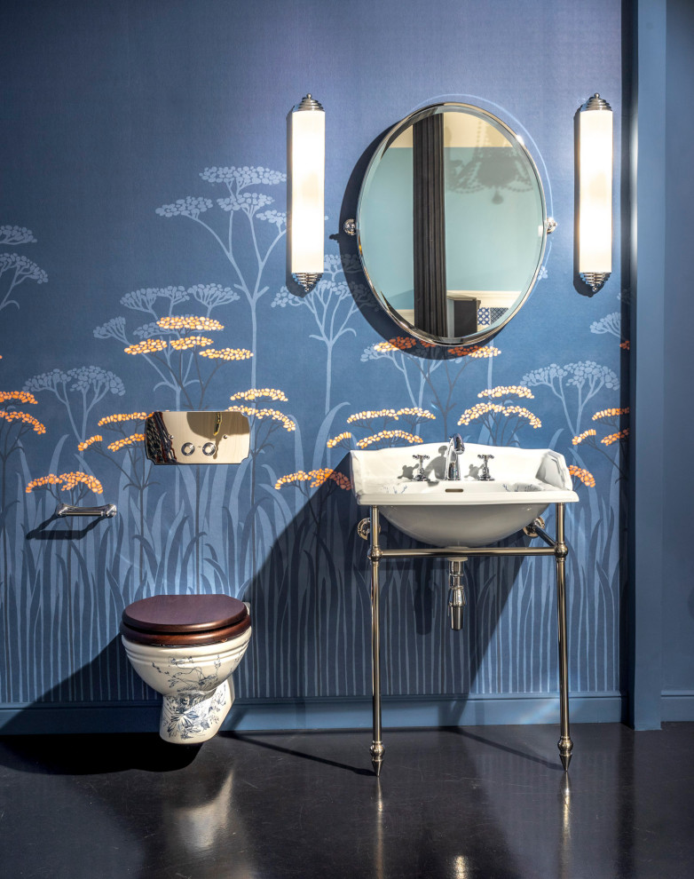 Imagen de cuarto de baño único y de pie clásico de tamaño medio con bañera exenta, sanitario de pared, paredes azules, papel pintado y lavabo tipo consola