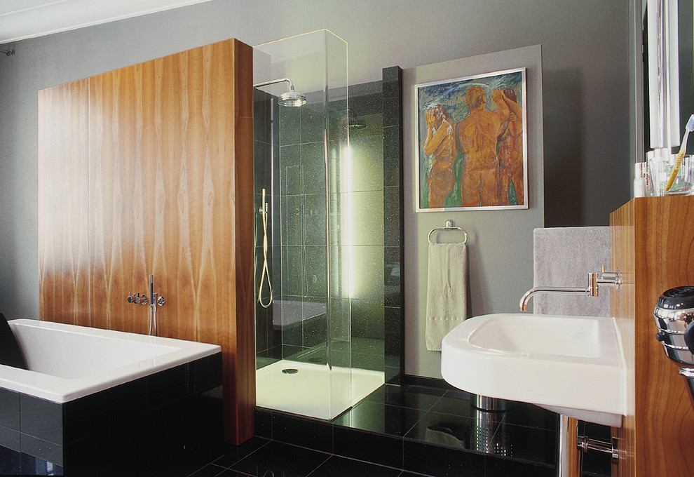 Стильный дизайн: большая ванная комната в современном стиле с отдельно стоящей ванной, душем в нише, черной плиткой, серыми стенами и подвесной раковиной - последний тренд