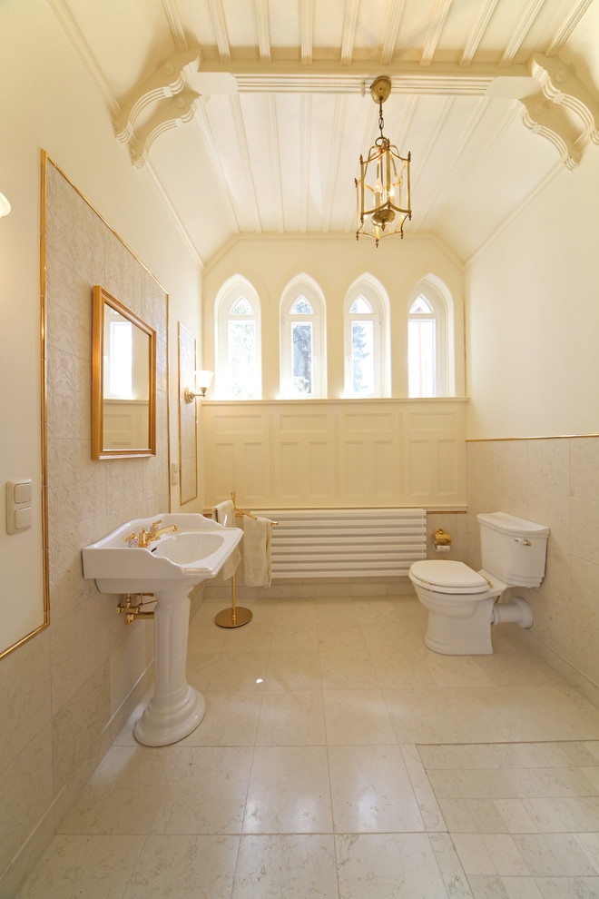 Cette image montre une salle d'eau victorienne de taille moyenne avec un lavabo de ferme, un mur beige, une douche ouverte, un carrelage beige, un carrelage de pierre, un sol en calcaire et WC à poser.
