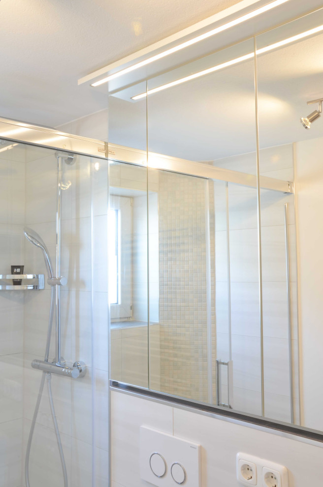 Modernes Duschbad mit weißen Schränken, offener Dusche, Wandtoilette, weißen Fliesen, beiger Wandfarbe, dunklem Holzboden, Unterbauwaschbecken, braunem Boden, Schiebetür-Duschabtrennung und weißer Waschtischplatte in München
