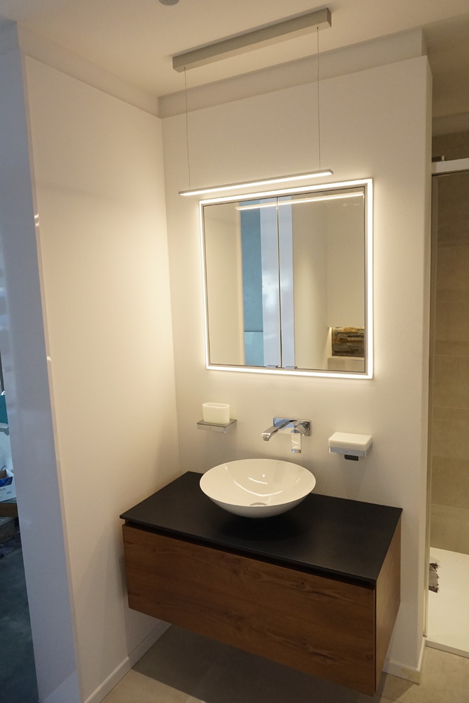 Kleines Modernes Badezimmer mit flächenbündigen Schrankfronten, dunklen Holzschränken, Aufsatzwaschbecken und Mineralwerkstoff-Waschtisch in Stuttgart