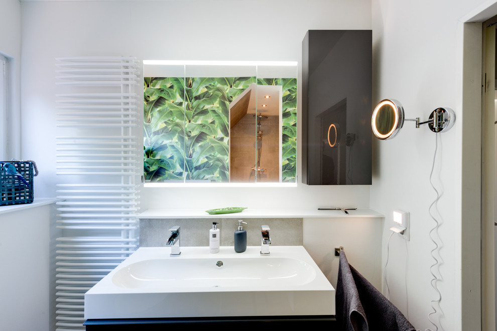 Idéer för att renovera ett mellanstort tropiskt vit vitt badrum med dusch, med släta luckor, svarta skåp, våtrum, en vägghängd toalettstol, grön kakel, porslinskakel, gröna väggar, vinylgolv, ett fristående handfat, bänkskiva i akrylsten och brunt golv