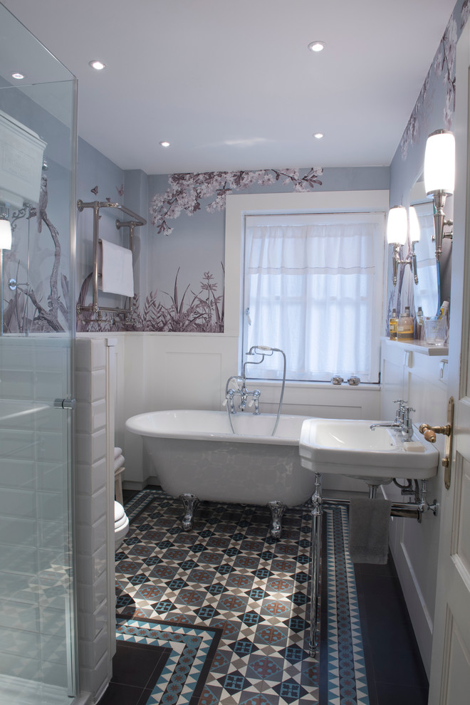 Inredning av ett klassiskt mellanstort en-suite badrum, med ett badkar med tassar, en hörndusch, flerfärgad kakel, flerfärgade väggar, ett väggmonterat handfat och cementgolv