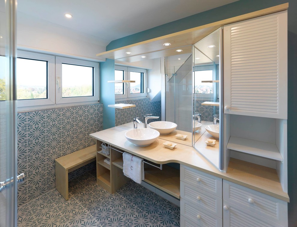 Inredning av ett medelhavsstil mycket stort badrum med dusch, med luckor med lamellpanel, vita skåp, vit kakel, blå kakel, keramikplattor, blå väggar, ett fristående handfat, träbänkskiva, blått golv, dusch med gångjärnsdörr och klinkergolv i keramik
