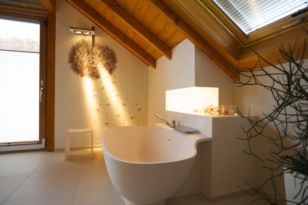 Cette image montre une grande salle d'eau design avec une baignoire indépendante, une douche à l'italienne, un bidet, un carrelage noir et blanc, des dalles de pierre, un mur blanc, un lavabo intégré, un sol beige et un plan de toilette blanc.