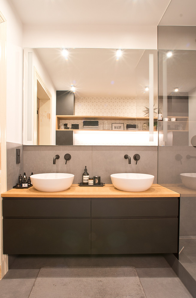 Foto di una stanza da bagno minimal con ante nere, piastrelle grigie, lavabo a bacinella e top beige
