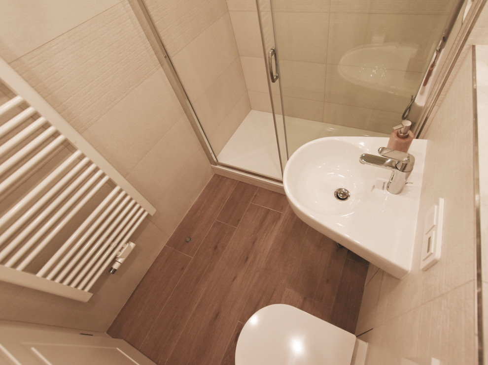 Exempel på ett litet modernt vit vitt badrum med dusch, med en dusch i en alkov, en vägghängd toalettstol, beige kakel, keramikplattor, vita väggar, klinkergolv i keramik, ett väggmonterat handfat, bänkskiva i kvarts, brunt golv och dusch med skjutdörr