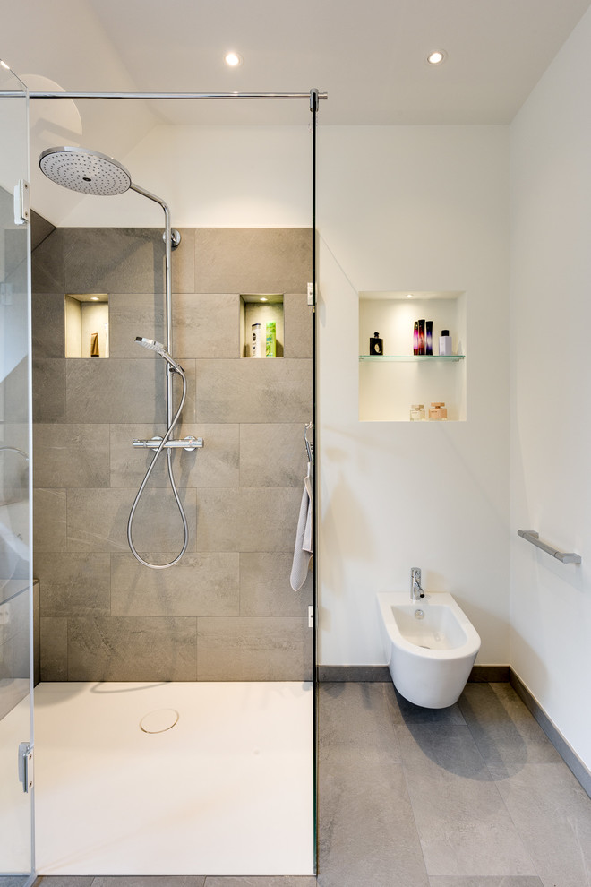 Idéer för stora funkis brunt badrum med dusch, med släta luckor, vita skåp, ett fristående badkar, våtrum, en vägghängd toalettstol, vit kakel, keramikplattor, vita väggar, klinkergolv i keramik, ett fristående handfat, bänkskiva i akrylsten och beiget golv