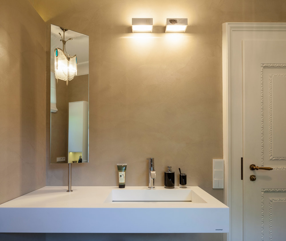 Aménagement d'une salle de bain contemporaine avec un mur beige et un lavabo suspendu.