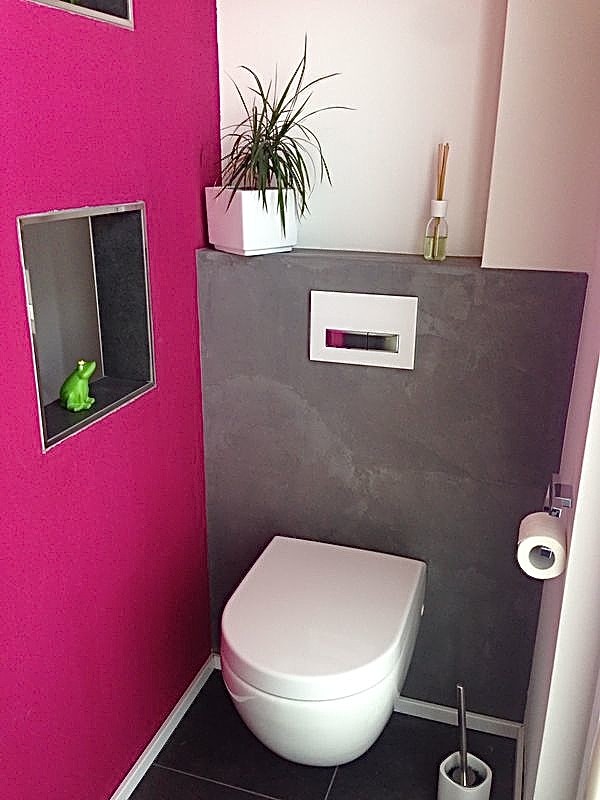 Kleine Moderne Gästetoilette mit Wandtoilette, rosa Wandfarbe, Kalkstein und schwarzem Boden in Köln