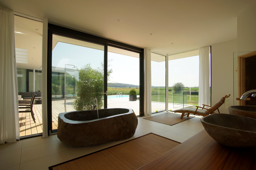 Modernes Badezimmer En Suite mit freistehender Badewanne, Zementfliesen, weißer Wandfarbe, Aufsatzwaschbecken und Waschtisch aus Holz in München