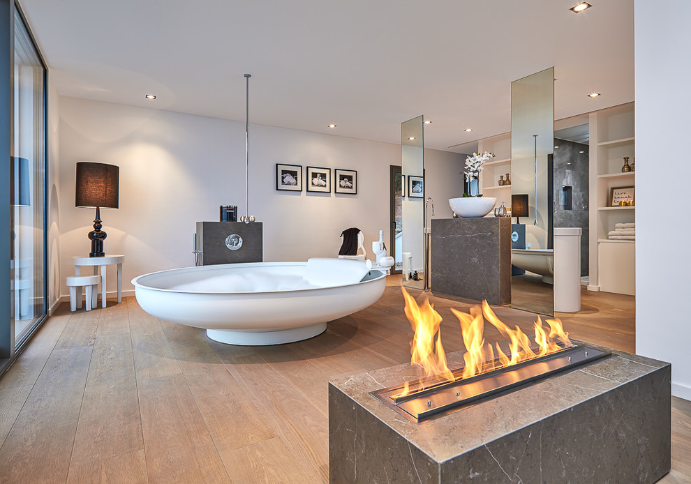 Geräumiges Modernes Badezimmer En Suite mit freistehender Badewanne, weißer Wandfarbe, braunem Holzboden, Aufsatzwaschbecken und braunem Boden in Palma de Mallorca
