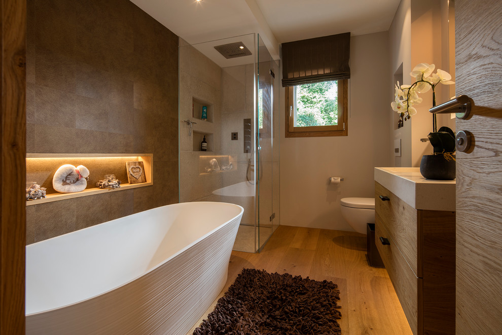 Photo of a medium sized contemporary shower room bathroom in Other with flat-panel cabinets, medium wood cabinets, a built-in shower, beige tiles, stone tiles, white walls, light hardwood flooring and a vessel sink.