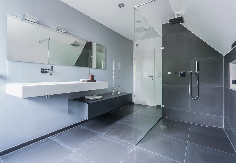 Свежая идея для дизайна: большая серо-белая ванная комната в стиле модернизм с плоскими фасадами, серыми фасадами, душем без бортиков, серой плиткой, серыми стенами, подвесной раковиной, открытым душем и зеркалом с подсветкой - отличное фото интерьера