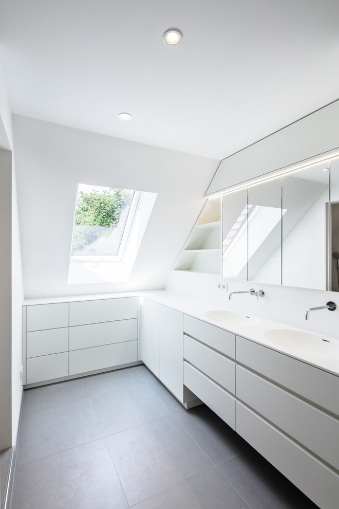 Idéer för ett mellanstort modernt badrum, med släta luckor, vita skåp, cementgolv, ett integrerad handfat, bänkskiva i akrylsten och grått golv