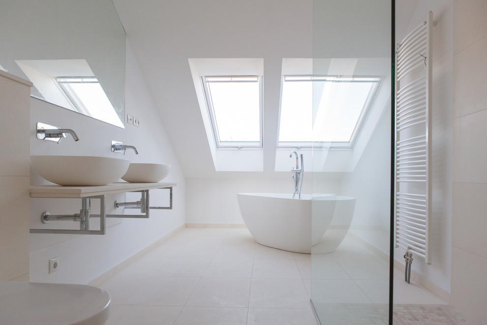 Ejemplo de cuarto de baño moderno con bañera exenta, paredes blancas, lavabo sobreencimera y ducha abierta