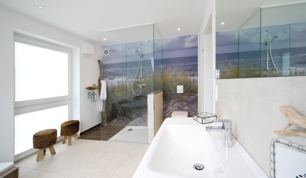 Foto de cuarto de baño escandinavo con bañera esquinera, ducha a ras de suelo, sanitario de pared, baldosas y/o azulejos marrones, baldosas y/o azulejos de piedra, paredes multicolor y lavabo sobreencimera