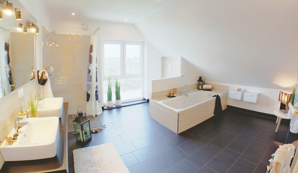 Foto de sauna nórdica con bañera exenta, sanitario de pared, baldosas y/o azulejos beige, baldosas y/o azulejos de piedra, paredes blancas, lavabo sobreencimera y encimera de acrílico