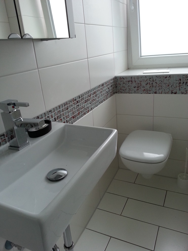 Small trendy 3/4 white tile white floor bathroom photo in Essen with flat-panel cabinets, white cabinets, a one-piece toilet, white walls, a vessel sink and limestone countertops